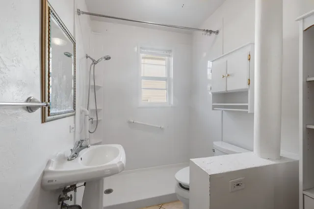 a bathroom with a sink a toilet and shower