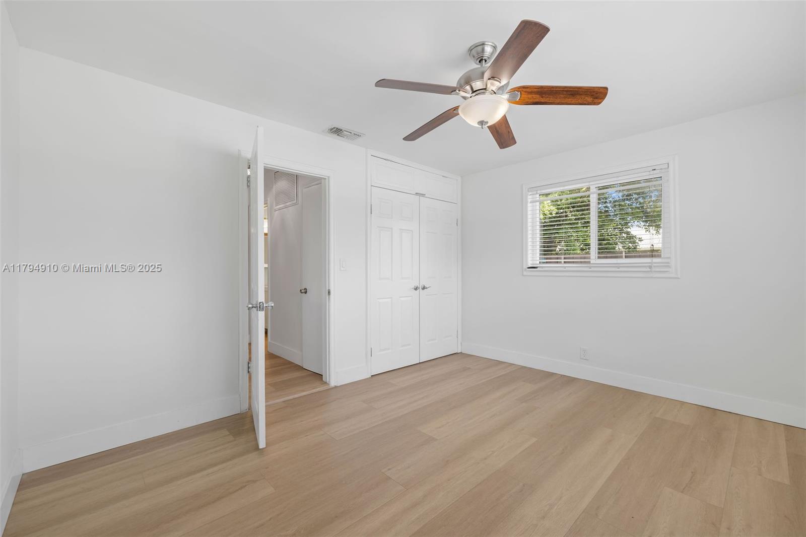 4401 Madison Street Hollywood, FL 33021 - Photo 18 of 27 a view of an empty room with wooden floor and a ceiling fan