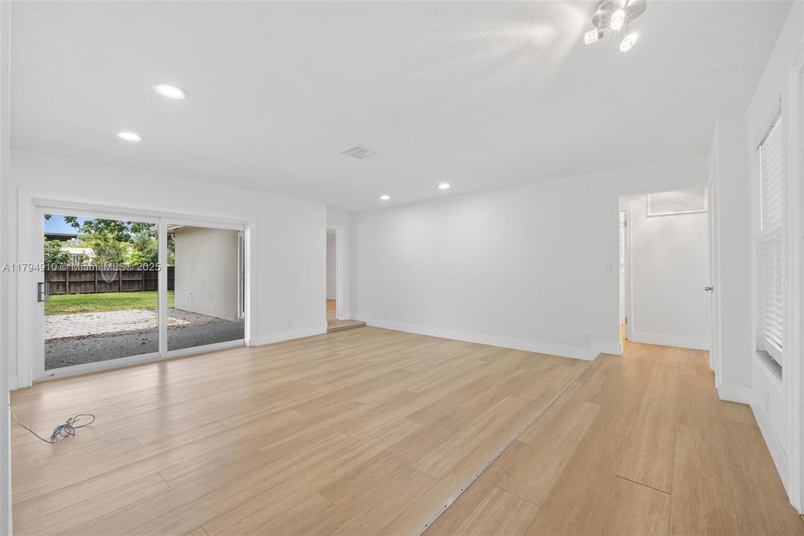 4401 Madison Street Hollywood, FL 33021 - Photo 4 of 27 a view of an empty room with wooden floor and a window