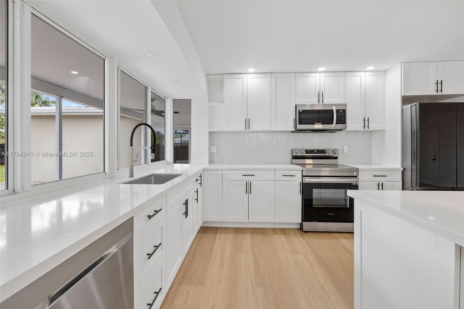 4401 Madison Street Hollywood, FL 33021 - Photo 6 of 27 a kitchen with stainless steel appliances a refrigerator stove a sink and a microwave