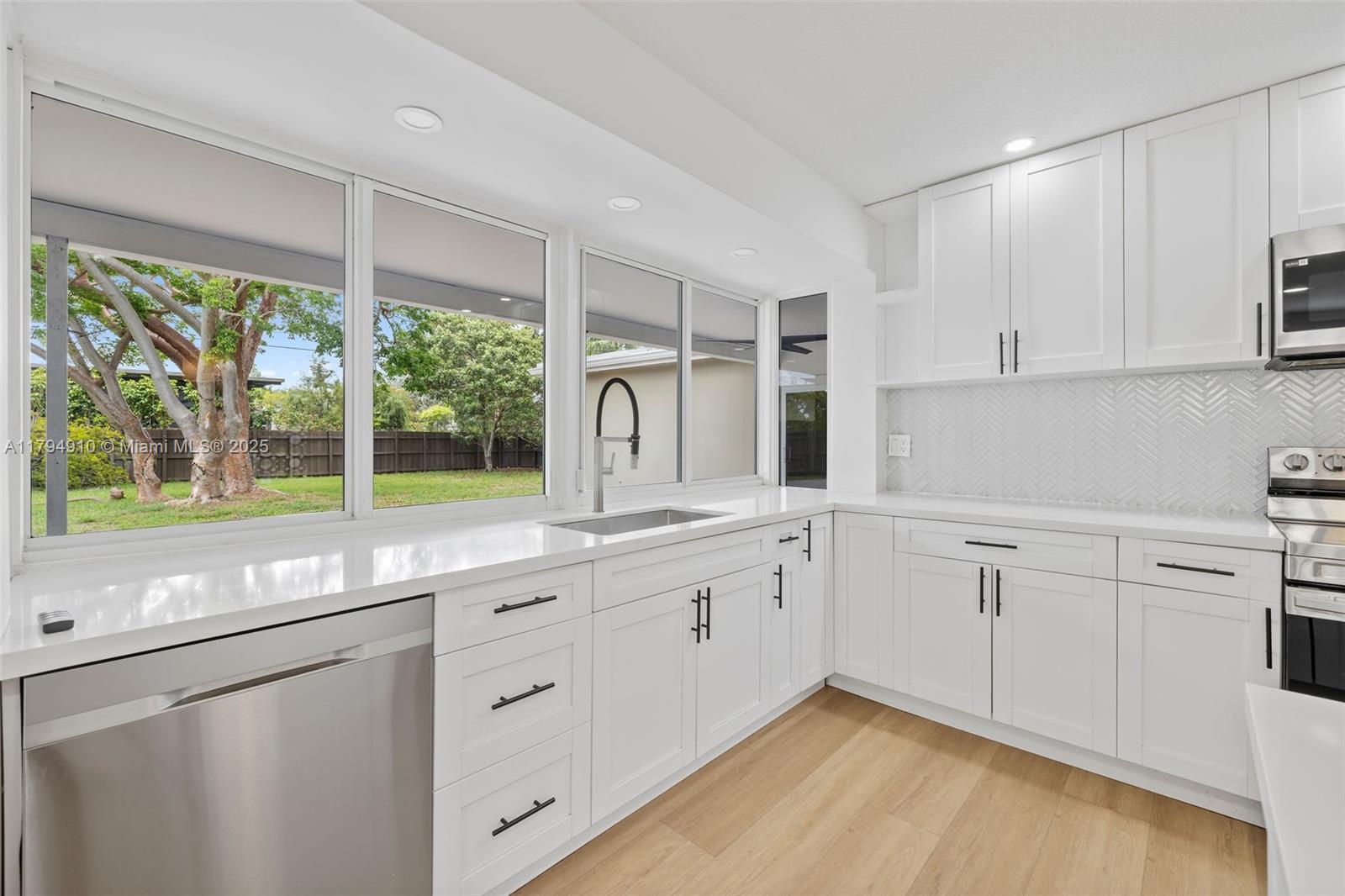 4401 Madison Street Hollywood, FL 33021 - Photo 7 of 27 a kitchen with white cabinets and a large window