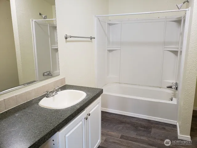 a bathroom with a granite countertop sink toilet and shower