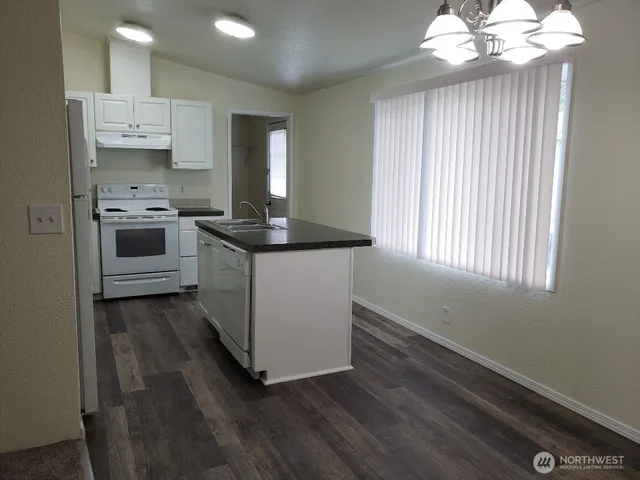 a kitchen with a stove and a white cabinet