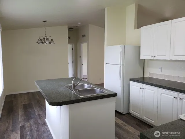 a kitchen with stainless steel appliances granite countertop a sink and a refrigerator