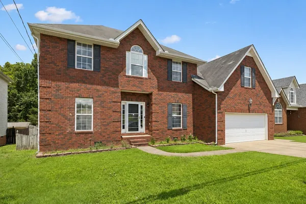 a front view of a house with a yard and garage