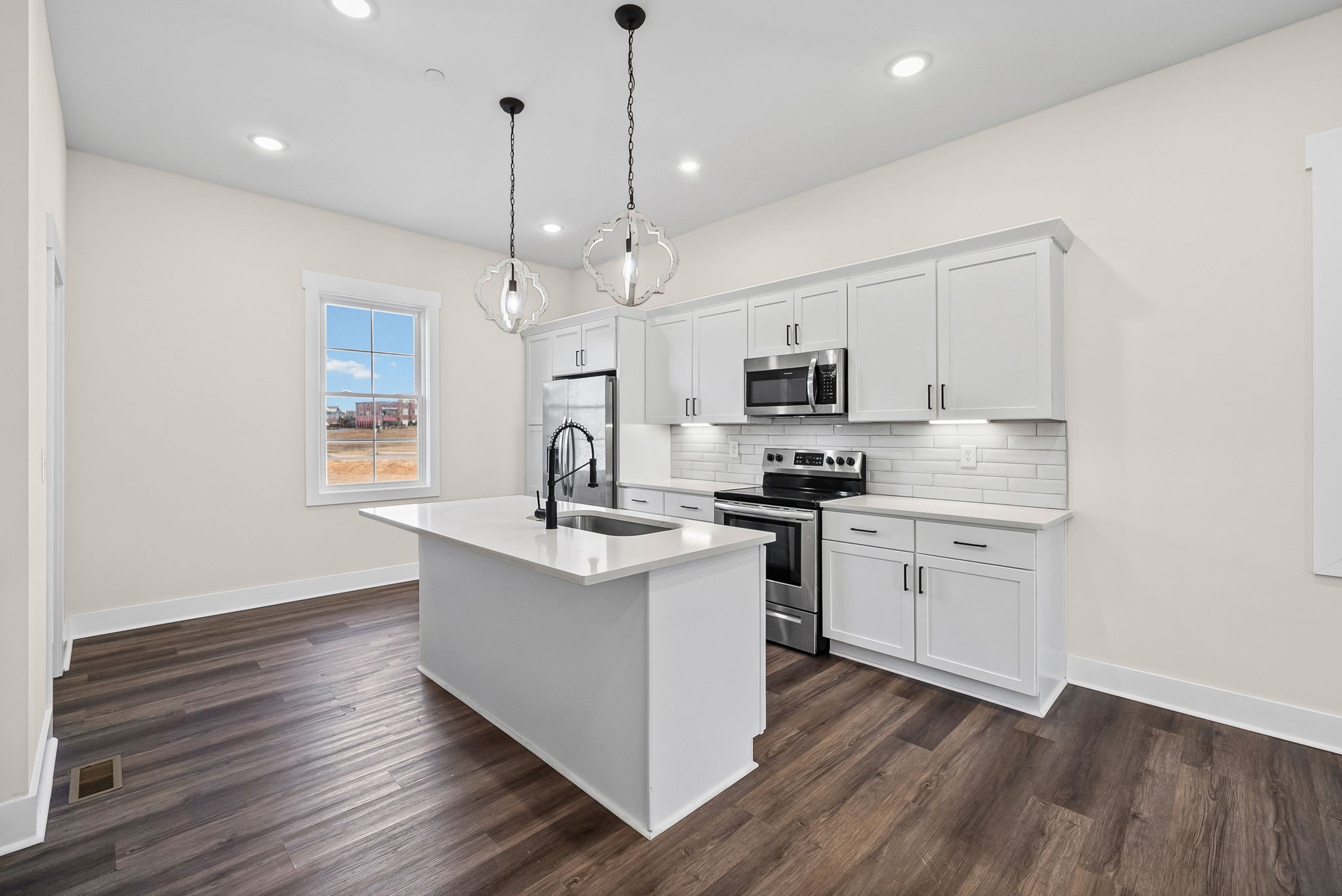 434 Centre Street Pleasant View, TN 37146 - Photo 8 of 44 a kitchen with stainless steel appliances granite countertop a sink a stove a microwave oven a refrigerator with white cabinets and wooden floor