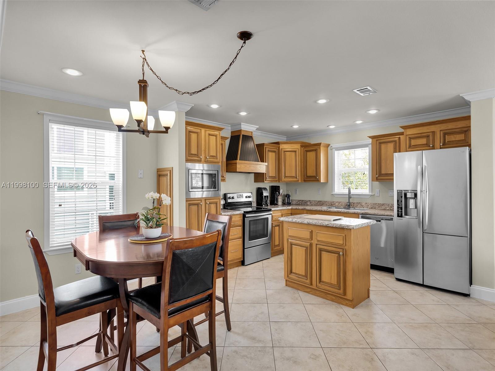 437 Pirates Road Summerland Key, FL 33042 - Photo 16 of 39 a kitchen with a dining table cabinets appliances and a window