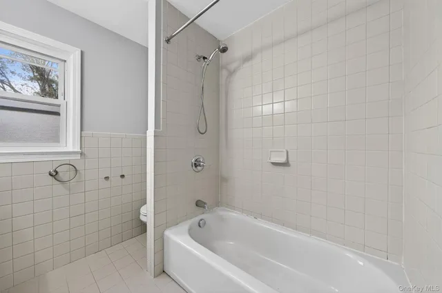 a white bath tub sitting next to a shower