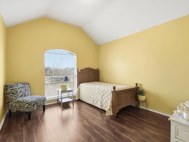 a bedroom with bed and wooden floor