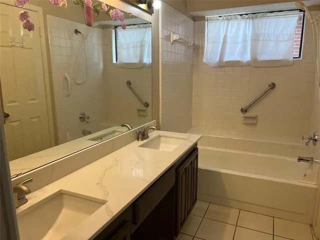 a bathroom with a sink vanity tub and shower