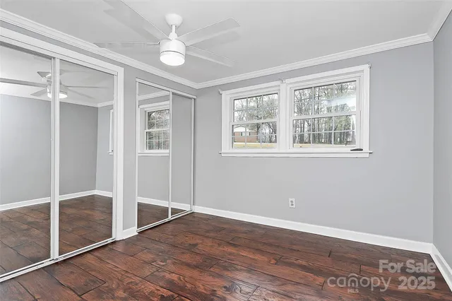 an empty room with wooden floor and window