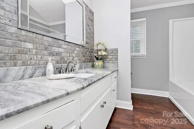 a bathroom with a granite countertop sink and a mirror