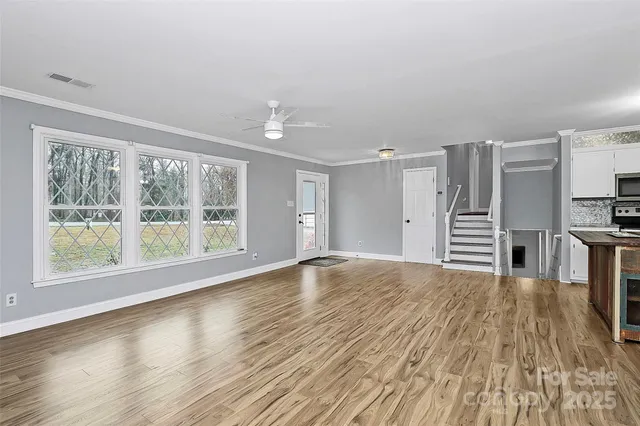 a view of empty room with wooden floor and fireplace