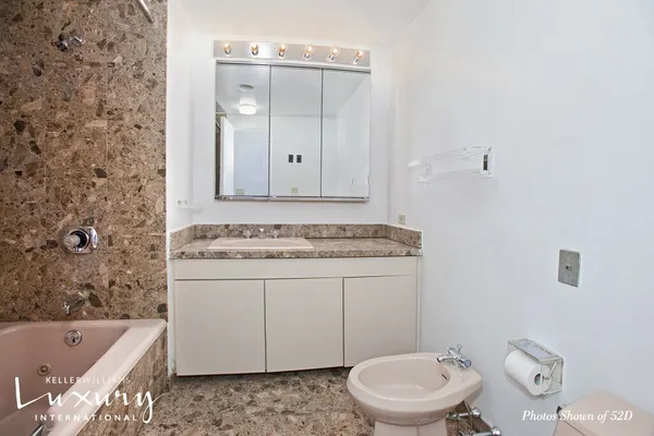 a bathroom with a granite countertop sink a toilet and bathtub