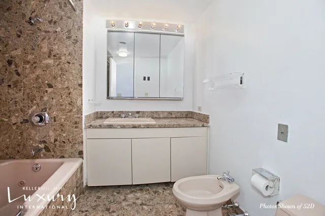 a bathroom with a granite countertop sink a toilet and bathtub