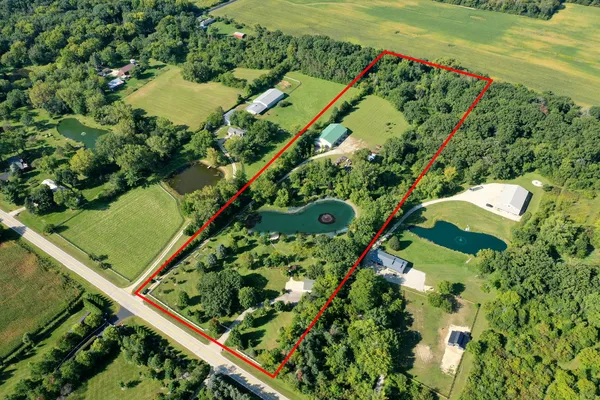 an aerial view of a resort with a yard and lake view