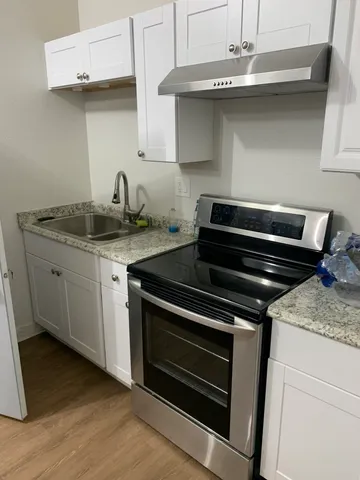 a kitchen with granite countertop a stove and a sink