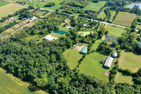 an aerial view of residential house with swimming pool and green space