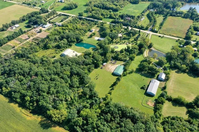 an aerial view of residential house with swimming pool and green space