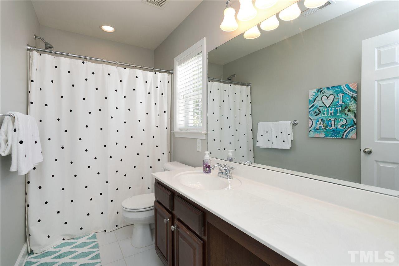 167 Solheim Lane Raleigh, NC 27603 - Photo 15 of 25 a bathroom with a sink a mirror a vanity and a shower