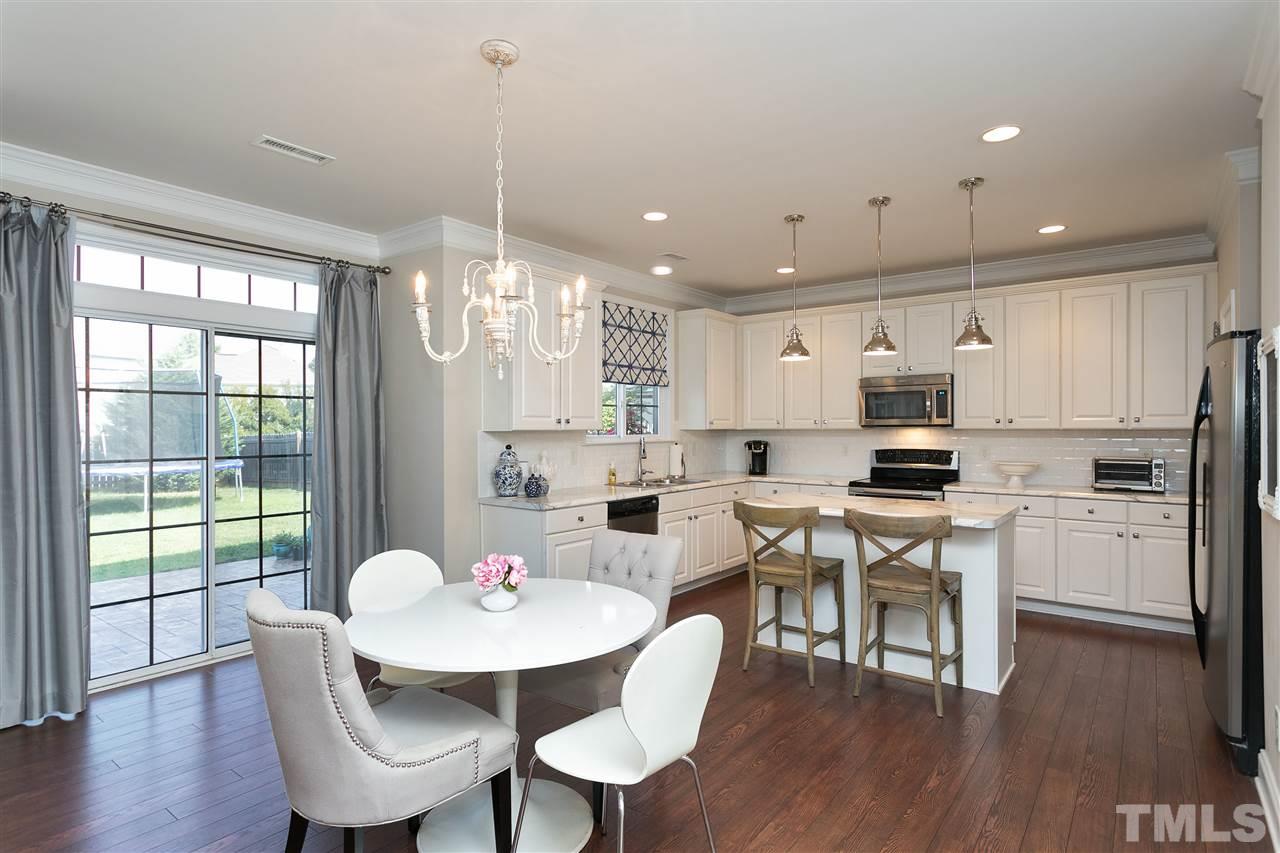 167 Solheim Lane Raleigh, NC 27603 - Photo 3 of 25 a kitchen with stainless steel appliances kitchen island granite countertop a dining table chairs and granite counter tops