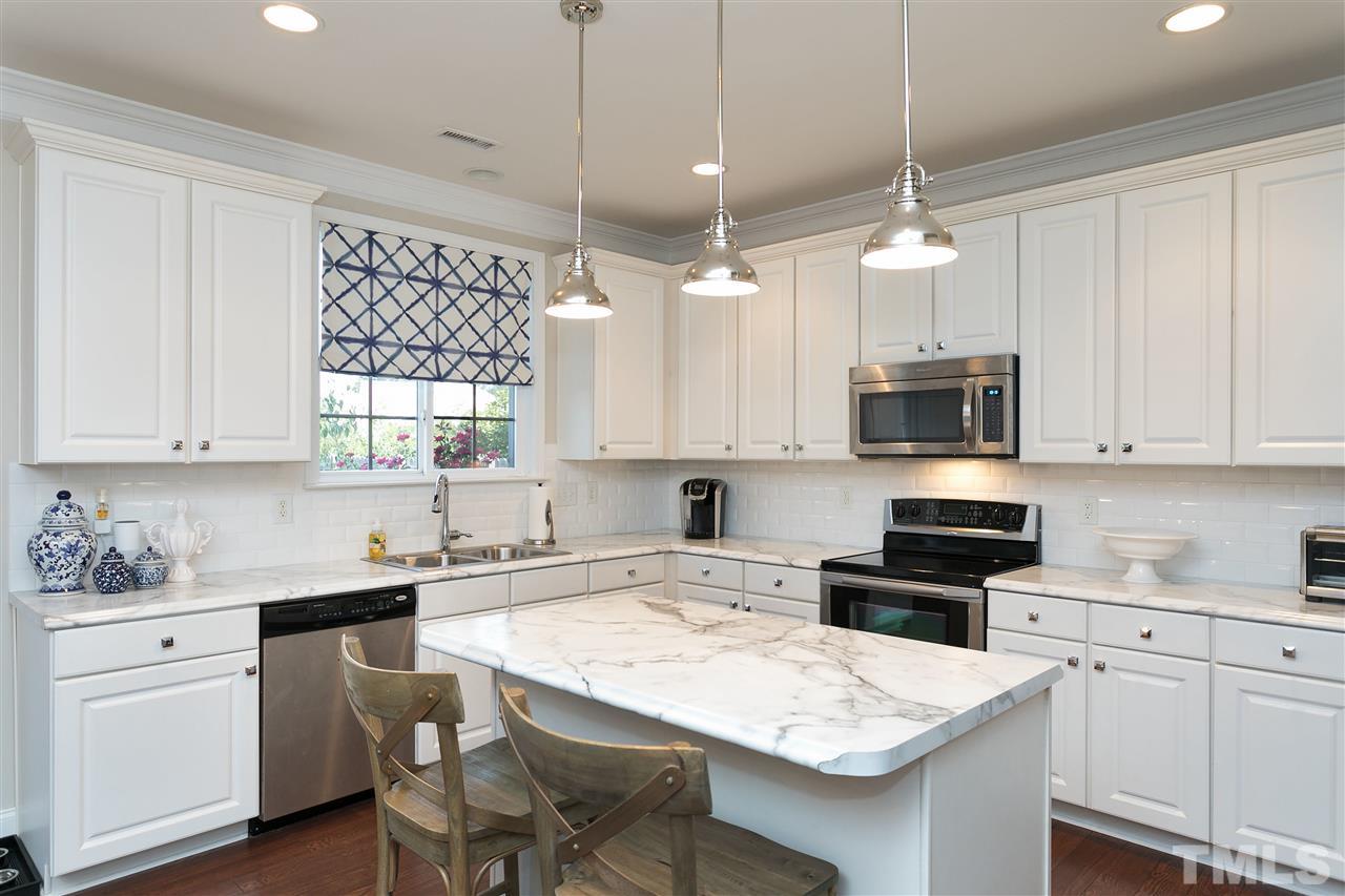 167 Solheim Lane Raleigh, NC 27603 - Photo 4 of 25 a kitchen with white cabinets and white appliances