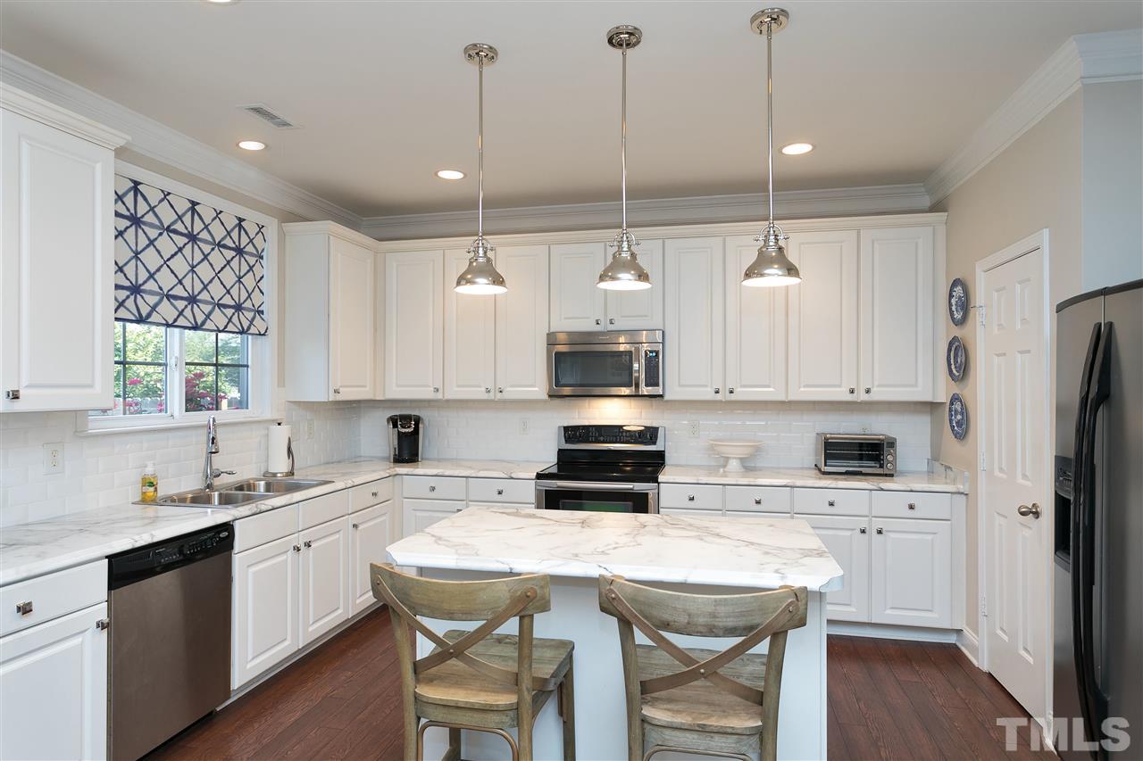 167 Solheim Lane Raleigh, NC 27603 - Photo 5 of 25 a kitchen with a white center island and cabinets