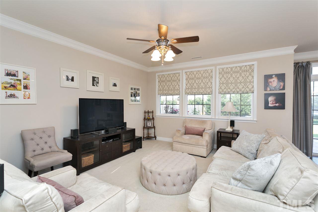 167 Solheim Lane Raleigh, NC 27603 - Photo 9 of 25 a living room with furniture a flat screen tv and a large window