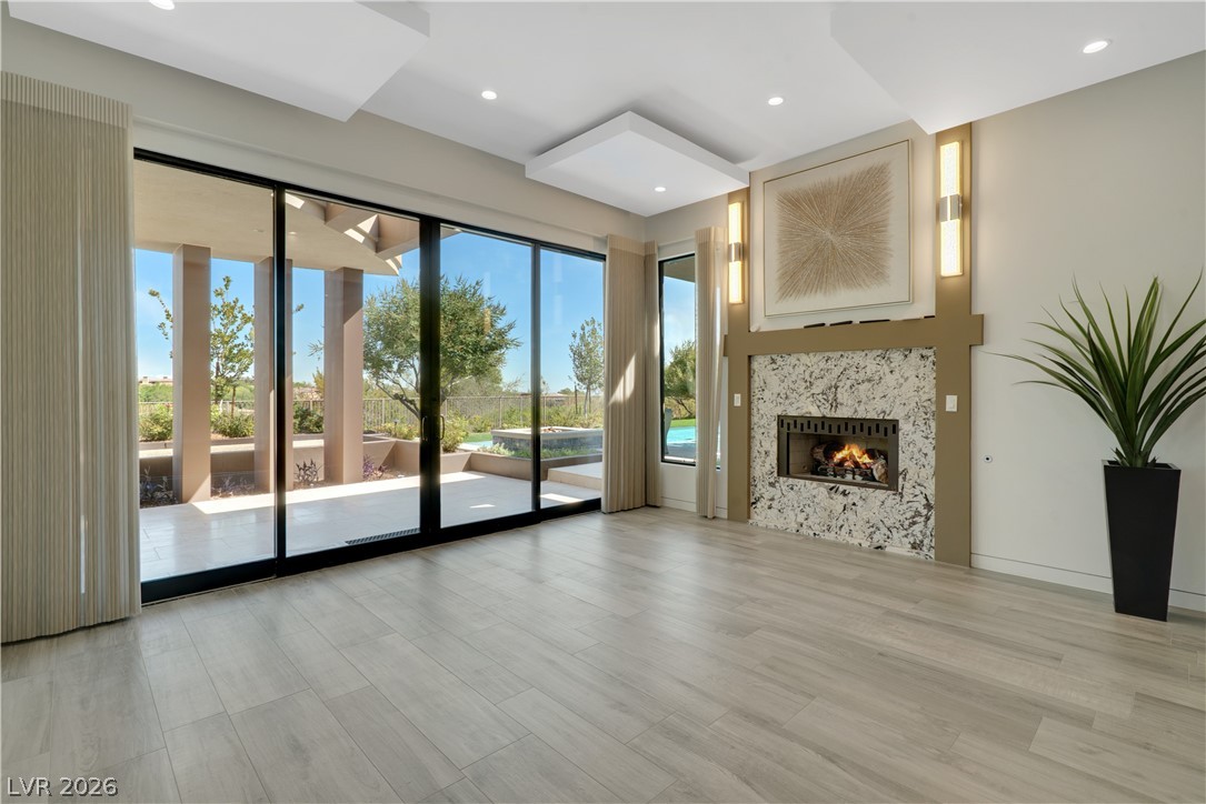 10 Ridge Blossom Road Las Vegas, NV 89135 - Photo 17 of 64 Primary bedroom with views of the pool and patio. Light wood finished floors, a high end fireplace, and recessed lighting