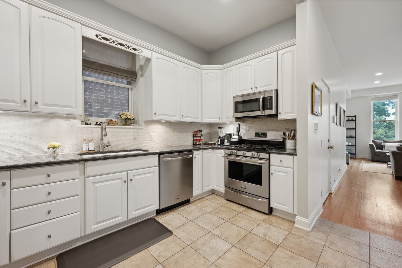1667 North Bissell Street, Unit 2 Chicago, IL 60614 - Photo 5 of 14 a kitchen with granite countertop white cabinets and stainless steel appliances