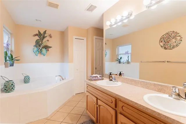 a bathroom with a tub a sink and mirror