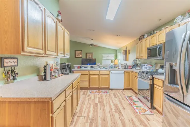 a kitchen with a refrigerator a sink and a stove top oven
