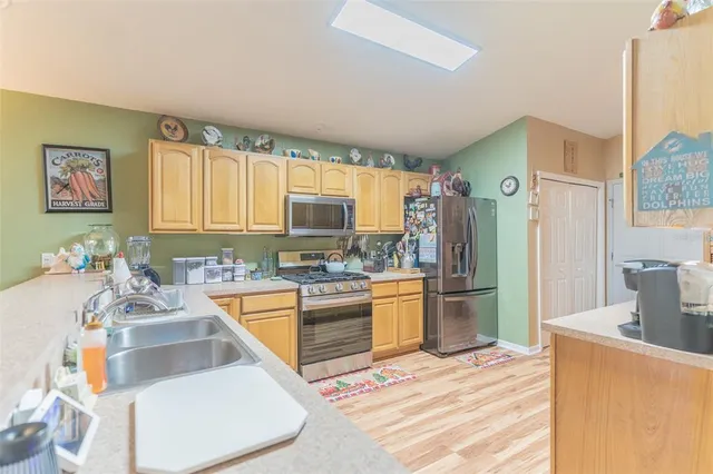 a kitchen with stainless steel appliances granite countertop a sink stove and refrigerator