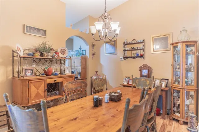 a room with chandelier fan and wooden furniture
