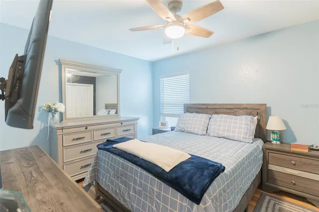 a bedroom with a bed and a flat tv screen on dresser