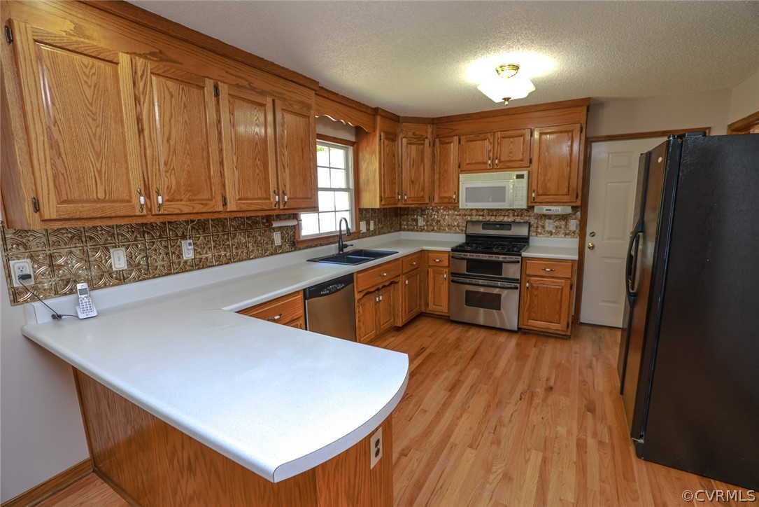 7100 Hair Road Disputanta, VA 23842 - Photo 8 of 40 a kitchen with stainless steel appliances granite countertop a sink a stove a refrigerator a washer dryer and white cabinets