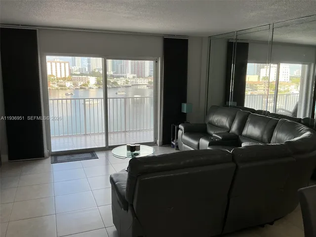 a living room with furniture and a floor to ceiling window