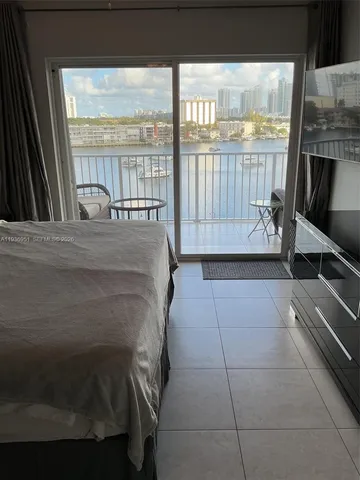 a bed sitting in a balcony next to a large window