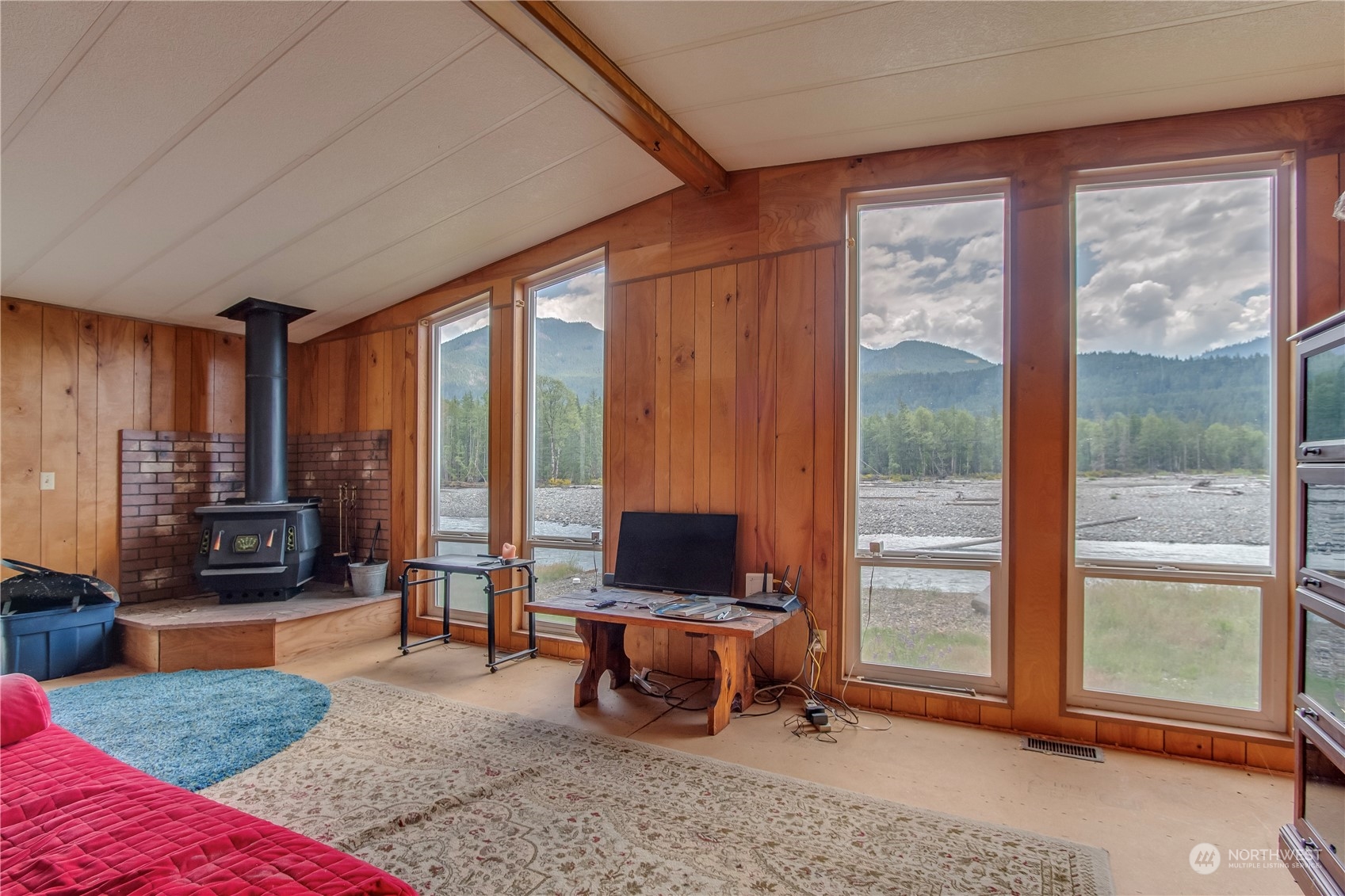 140 Maple Place Packwood, WA 98361 - Photo 12 of 39 a living room with furniture a rug and a floor to ceiling window