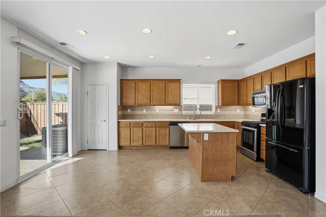 an empty room with windows and ceiling fan