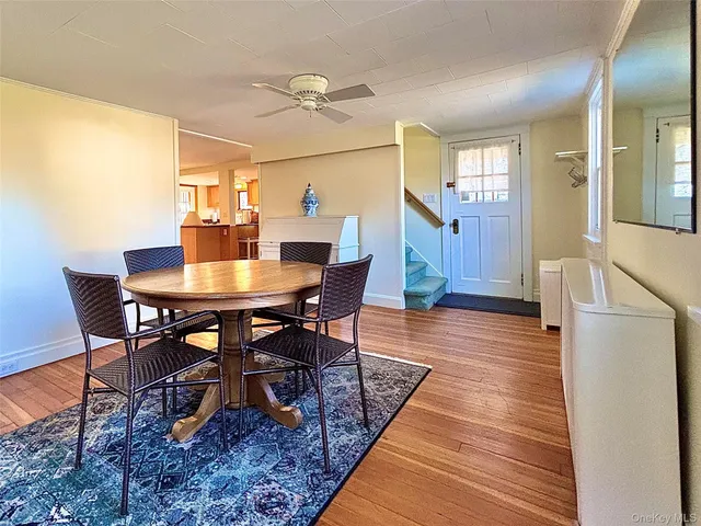 a dining room with wooden floor a chandelier a wooden table and chairs