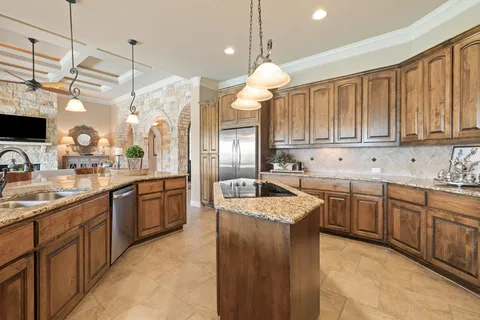 a kitchen with granite countertop a sink stove and cabinets