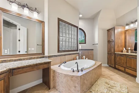 a bathroom with a tub a sink and a large mirror
