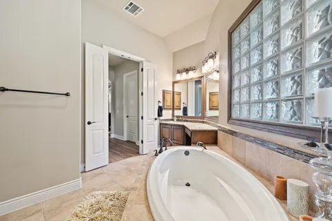 a en suite bathroom with a sink and a large mirror