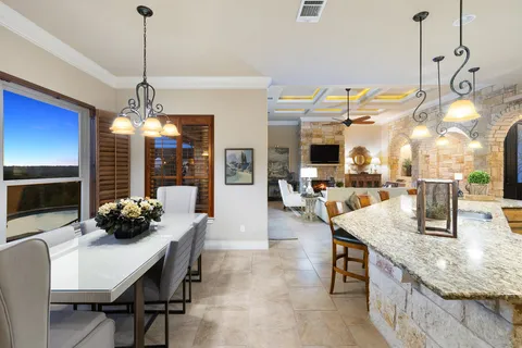 a kitchen with granite countertop a table and chairs
