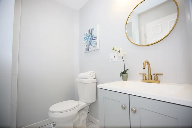 a bathroom with a sink mirror and toilet