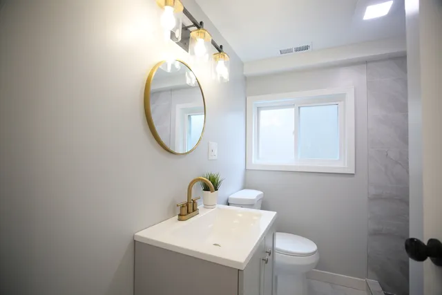 a bathroom with a sink mirror and toilet