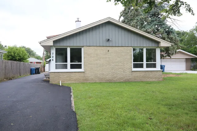 a view of a house with a yard and wooden fence