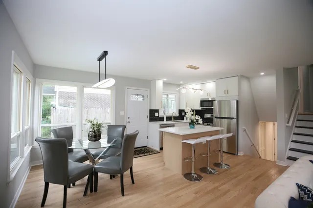 a dining room with furniture a chandelier and wooden floor