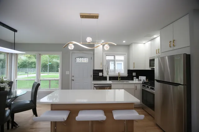 a kitchen with a table chairs refrigerator and microwave